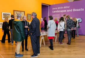 People stand in groups in the Denis Wirth Miller, Landscapes and Beasts Exhibition at Firstsite 2022.