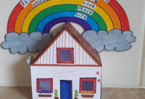 Paper house with rainbow above