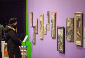 A visitor looking at artworks in the Lucy Harwood exhibition Bold Impressions at Firstsite.