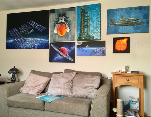 Living room with paintings of aerospace and astronomy on the walls.