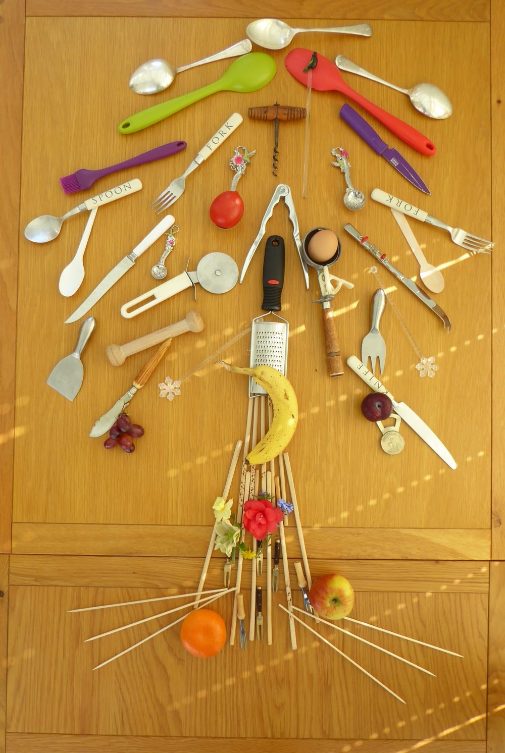 Tree sculpture made from fruit, vegetables, cutlery, chopsticks and an egg.