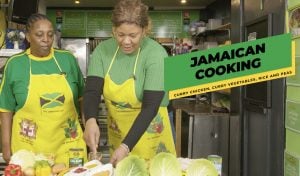 two women prepare Jamaican food in the S&S café kitchen