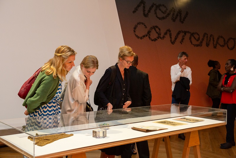 A group of people look at items in a vitrine