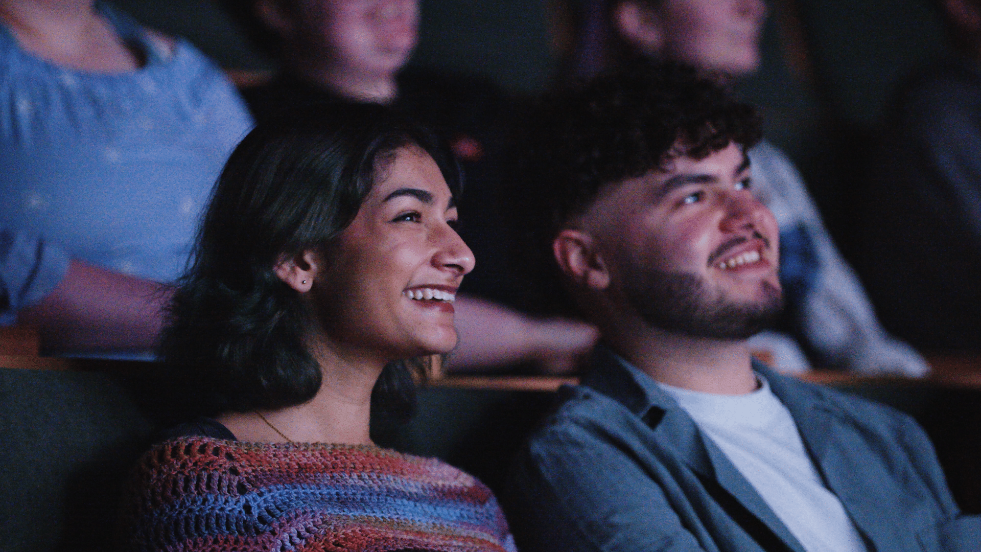 Two people at the Firstsite cinema looking at the screen and smiling. This is during the Freshers Fortnight at Firstsite.