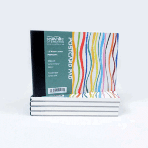 A stack of postcard pads showing the front cover including colourful stripes and a panel with information about the product.