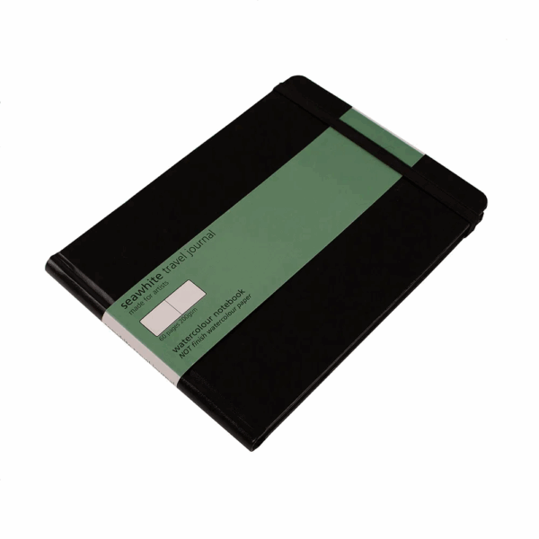 Front cover of the travel journal set at an angle. Cover is black, there is a green label giving some information on the product.